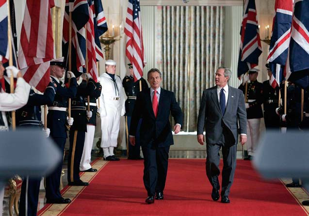 President George W. Bush, right, and British Prime Minister Tony Blair arrive for a joint news conference in the East Room at the White House on Tuesday, June 7, 2005. (Photo: Doug Mills / The New York Times) 